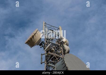 Ein Fernmeldeturm oben vor dem Hintergrund des klaren blauen Himmels Stockfoto