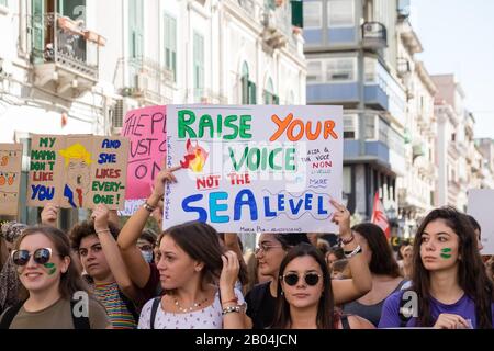 Eine Prozession, die aus vielen jungen Studenten besteht, die gegen den Klimawandel protestieren, indem sie Plakate und Banner mit Botschaften zeigen. Stockfoto