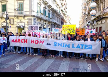 Eine Prozession, die aus vielen jungen Studenten besteht, die gegen den Klimawandel protestieren, indem sie Plakate und Banner mit Botschaften zeigen. Stockfoto