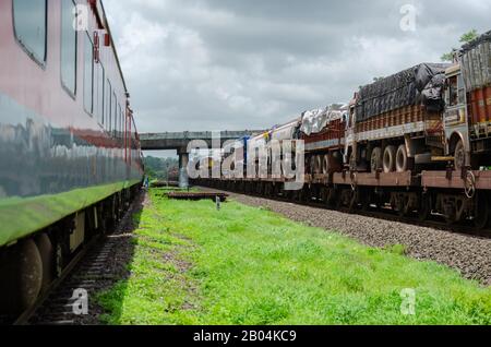 Ro-Ro-Zug (Roll On Roll Off), der LKWs am Bahnhof Khed der Konkan Railway, Maharashtra, Indien, transportiert Stockfoto