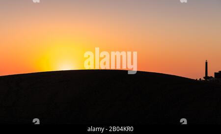 Maspalomas Dünen und Leuchtturm in Silhouette bei Sonnenuntergang, Gran Canaria, Kanarische Inseln Stockfoto