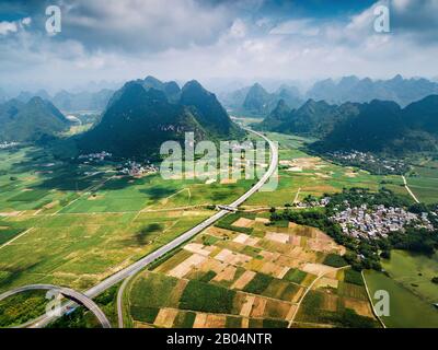 Malerische Autobahn in der chinesischen Provinz Guangxi, umgeben von Reisfeldern und Karstfelsen Stockfoto