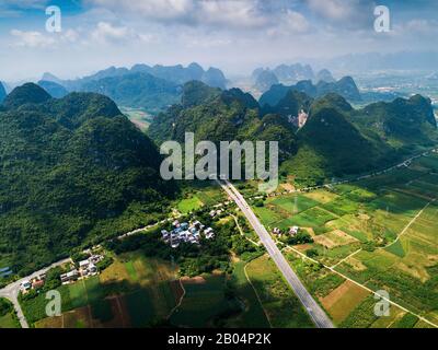 Malerische Autobahn in der chinesischen Provinz Guangxi, umgeben von Reisfeldern und Karstfelsen Stockfoto