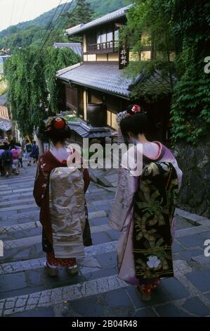 Straßenszene mit einer Geisha, die Schritte im historischen Gion District von Kyoto, Japan, runter geht. Stockfoto