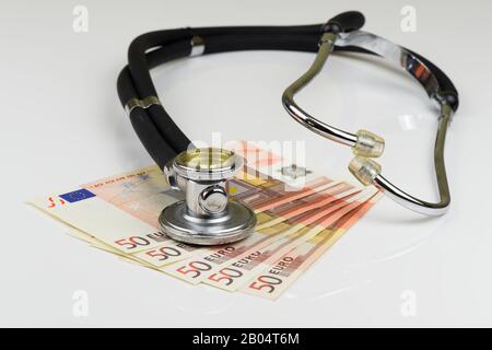 Hochwinkeliger Blick auf Stethoskop und Euro-Banknoten auf weißem Hintergrund Stockfoto