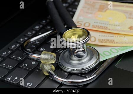 Hochwinkelige Ansicht von Stethoskop und Eurokurs auf schwarzer Computertastatur Stockfoto
