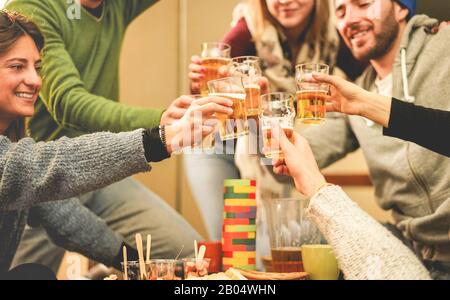 Fröhliche Freunde jubeln mit halbfeinem Bier im Pub-Restaurant - Junge Leute haben Spaß bei der Chalet-Bar-Party - Jugend, Urlaub und Nachtleben Lifestyle Stockfoto