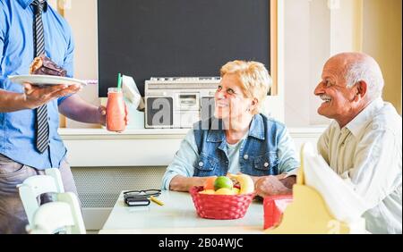 Fröhliches älteres Paar frühstückt morgens im Vintage-Bar-Restaurant - Fröhliches älteres und gesundes Lifestyle-Konzept - Konzentration auf das Gesicht des Menschen Stockfoto
