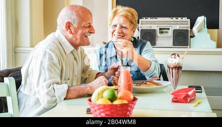 Fröhliches älteres Paar frühstückt morgens im Vintage-Bar-Restaurant - Fröhliche Senioren, Liebe und gesundes Lifestyle-Konzept - Konzentrieren Sie sich auf den Menschen Stockfoto
