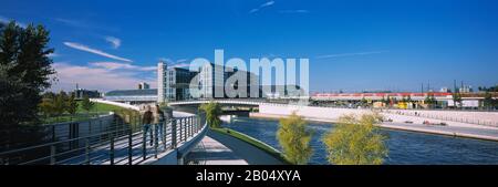 Zwei Menschen spazieren auf einem Fußweg entlang eines Flusses, Spree, Hauptbahnhof, Berlin, Deutschland Stockfoto