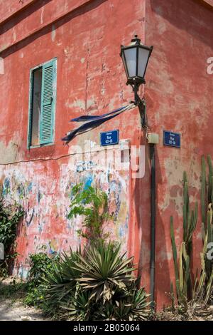 Straßenszene mit Details alter Kolonialhäuser auf Goree Island im Atlantik außerhalb von Dakar im Senegal, Westafrika. Stockfoto