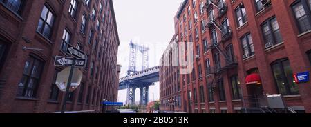 Blick auf eine Hängebrücke im niedrigen Winkel durch Gebäude, Manhattan Bridge, Brooklyn, New York City, New York State, USA Stockfoto
