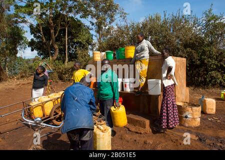 Die Einheimischen bekommen Wasser aus einem modernen Brunnen in Karatu in Tansania, Ostafrika. Stockfoto