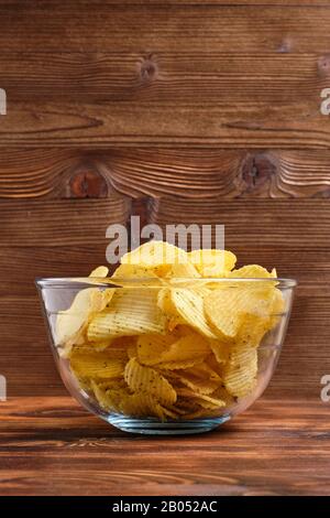 Gläser mit Spänen auf einem Hintergrund aus gebranntem Holzhintergrund mit Kopierraum. Vertikal. Nahaufnahme. Stockfoto