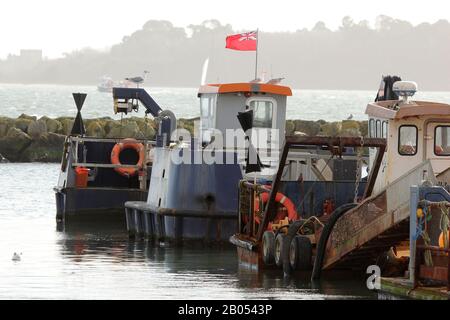 Alte, verlassene Boote im Poole Harbour mit Brownsea Island im Hintergrund Stockfoto