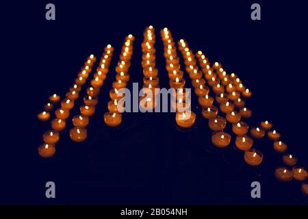 Kerzen in einer Reihe brennen Stockfoto