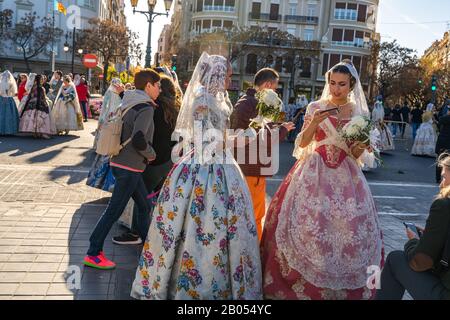 Valencia, Spanien, 18. März 2019. Valencianisches Festival von Fallas. Festzug im Zentrum der Stadt. Junge Frauen Falleras mit Smartphones. Stockfoto