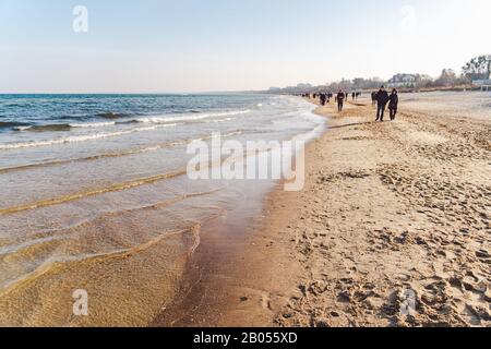 Polen, Sopot, 9. Februar 2020. Leute, die am Strand joggen. Nordic Walking. Wintersaison am Meer. Winterspaziergang am Strand. Menschen kühlen sich in Kälte ab Stockfoto