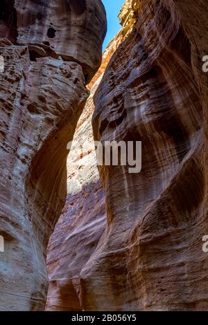 Atemberaubende natürliche Schlucht namens Al-Siq, in den roten Klippen am Wasserfluss gehauen, Petra uralter Stadtkomplex und Touristenattraktion, Haschemite Königreich Jordanien. Sonniger Wintertag, wolkenloser Himmel Stockfoto