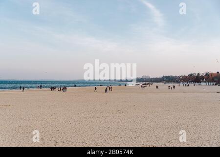 Polen, Sopot, 9. Februar 2020. Leute, die am Strand joggen. Nordic Walking. Wintersaison am Meer. Winterspaziergang am Strand. Menschen kühlen sich in Kälte ab Stockfoto