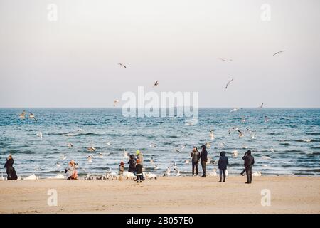 Polen, Sopot, 9. Februar 2020. Menschen am Strand in Sopot. Menge im Winter am Strand. Genießen Sie den Tag im sonnigen Winter in der Nähe des Meeres. Menschen, die hier spazieren gehen Stockfoto