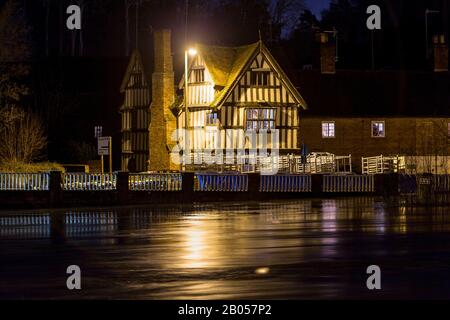 Bewdley, Worcestershire, Großbritannien. Februar 2020. Der Fluss Severn in Bewdley, Worcestershire steigt und wird gerade von den Hochwasserschutzanlagen entlang des Flussufers zurückgehalten. Die nächtlichen Expositionen zeigen, dass der Fluss sehr schnell fließt. Abgebildet ist ein altes historisches Gebäude, das von Überschwemmungen bedroht ist, wenn die Flussebenen die Verteidigung verletzen. Kredit: Peter Lopeman/Alamy Live News Stockfoto