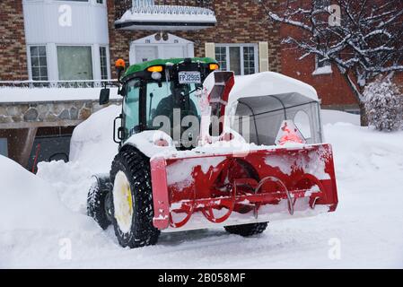 Schneefräse, die vor einem Haus, Laval, Provinz Quebec, Kanada, Schnee räumen. Stockfoto