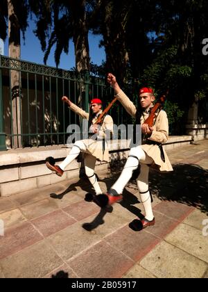 Evzones, die einen Wachwechsel in einer Straße, die Straße Herodou Attikou, den nationalen Garten von Athen, Athen, Attika, Griechenland durchführen Stockfoto