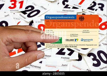 Hand, die eine Organspenderkarte vor Kalenderblättern hält, komponieren, Deutschland Stockfoto