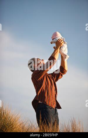Sehr reifer Mann seine Tochter oben in der Luft. Stockfoto