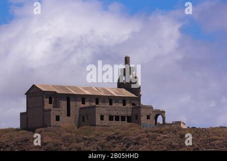 Juni 2017. Abades, Spanien, Kanarische Inseln, Teneras. Verlassene Kirche eines Spitals mit einem riesigen Kreuz auf einem kleinen Berg. Blauer Himmel mit Klo Stockfoto