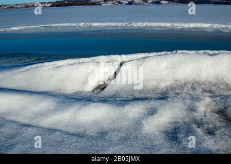 Riss im Eis am Seeufer Stockfoto