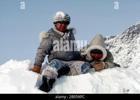 KANADA, ELLESMERE ISLAND, GRISE FJORD, ESKIMO KINDER, DIE IM SCHNEE SPIELEN Stockfoto