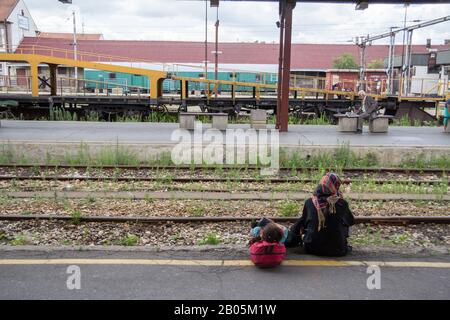 Belgrad, SERBIEN - 14. JULI 2015: Zwei Flüchtlinge, eine Frau, Mutter und ihre Tochter, die auf einen Zug im Belgrader Bahnhof an der Balkanroute warten, Stockfoto