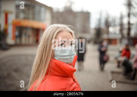 Junge Europäische Frau in einer Schutzmaske aus Coronavirus in der Stadt: Konzept für Gesundheit und Luftverschmutzung Stockfoto