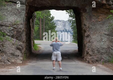 Keystone, SOUTH DAKOTA - 27. Juni 2014: Ein Tourist fotografiert durch den Scovel Johnson-Tunnel an der Iron Mountain Road mit Blick auf Mount Rushmore Stockfoto