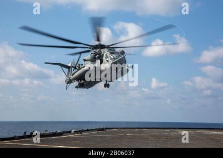 Philippinisches MEER (Feb. 4, 2020) EIN Super Stallion Helikopter CH-53E mit Marine Medium Tiltrotor Squadron 265 (Verstärkt), 31. Marine Expeditionary Unit (MEU) nähert sich dem Docklandungsschiff USS Germantown (LSD 42) der Whidbey-Island-Klasse bei einem Besuch, an Bord, bei der Suche und bei der Beschlagnahme (VBSS). VBSS verfügt über Kampffähige aus Luft, Boden und Oberflächen aus dem gesamten Blau-Grün-Team, um gegnerischen Schiffen auf See schnell zu verdirden. Germantown, Teil der America Expeditionary Strike Group, 31. MEU-Team, ist im 7. US-Flottenbereich tätig, um die Interoperabilität zu verbessern Stockfoto