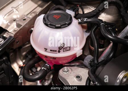 Close-up weiß Ausgleichsbehälter mit rosa Frostschutzmittel. Auto Kühlmittelstand im Kühler System im Auto, Automobil teil. Stockfoto