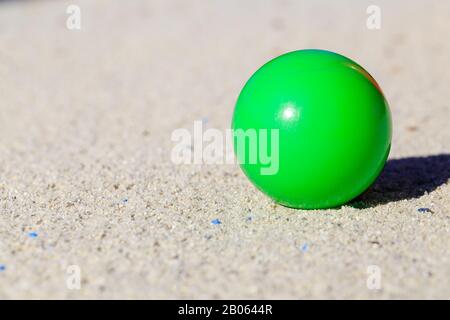 Grüner Ball auf Sand im Playground Yoga oder Spiel Stockfoto