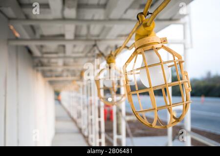 Konstruktionsleuchte im Gehweg der neuen Jobbörse gelbe Glühlampe Stockfoto