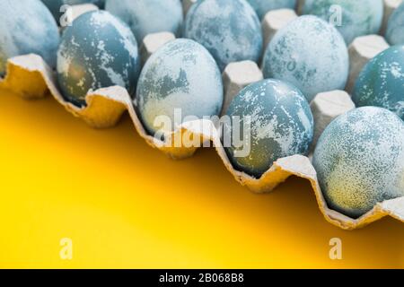 Blau strukturierte Ostereier auf hellgelber Ferienkulisse. Frühlingsferienkonzept. Copyspace. Flaches Lay. Draufsicht Stockfoto