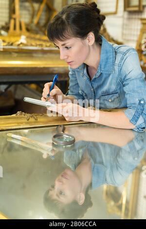 Kunsthandwerkerin, die an der Dekoration von Holzrahmen arbeitet Stockfoto