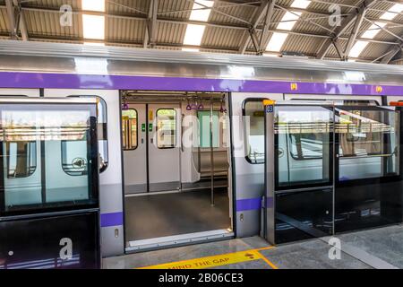 Der U-Bahn-Zug hält an einem Bahnhof und öffnet die Tür, um zu warten, bis Passagiere während der Hauptverkehrszeit an der U-Bahn-Station Kolkata East West einsteigen Stockfoto