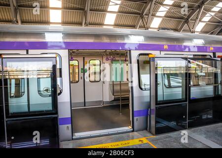 Der U-Bahn-Zug hält an einem Bahnhof und öffnet die Tür, um zu warten, bis Passagiere während der Hauptverkehrszeit an der U-Bahn-Station Kolkata East West einsteigen Stockfoto