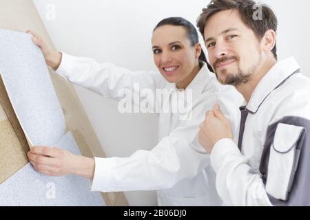 Mann und Frau wählen in ihrer neuen Wohnung Tapeten Stockfoto