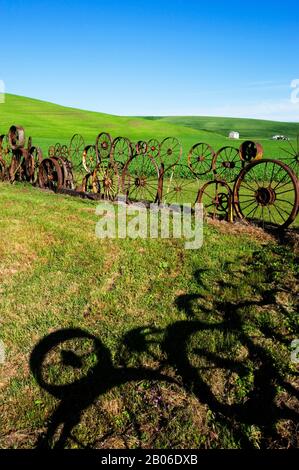 USA, WASHINGTON STATE, PALOUSE, UNIONTOWN, ZAUN AUS ALTEN RÄDERN IN DER DAHMEN BARN ART GALLERY Stockfoto