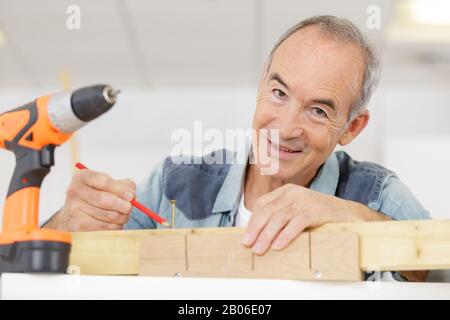 Ein senir-mann, der Holzarbeiten macht Stockfoto