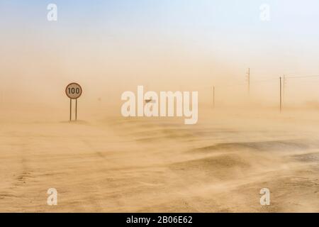 Sandsturm bedeckt die Straße von Swakopmund zur Walvis Bay in Namibia. Stockfoto