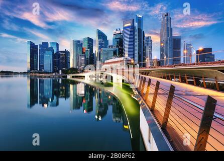 Skyline der Stadt Singapur bei Sonnenuntergang mit Brücke Stockfoto