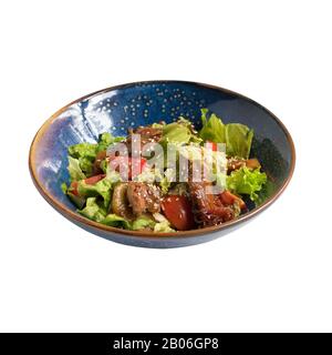 Warmer Rindersalat mit Salat und Tomaten, isoliert auf Weiß. Stockfoto